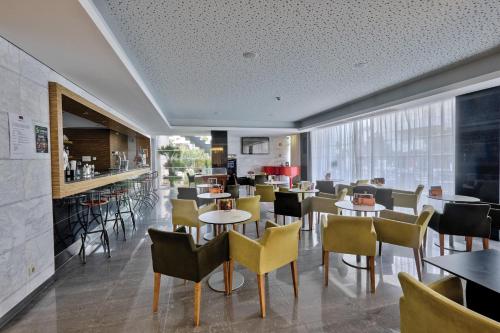 a restaurant with tables and chairs and a bar at Muthu Clube Praia da Oura in Albufeira