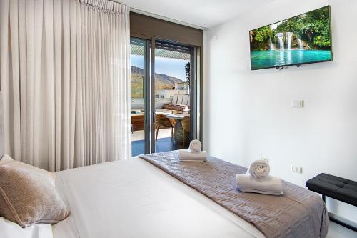 a bedroom with a bed with a view of the water at מגדליה סוויט - סויטה למשפחות עם בריכת זרמים וגקוזי פרטיים in Migdal