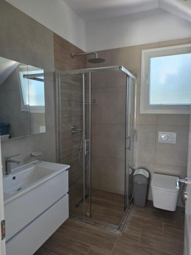 a bathroom with a shower and a sink and a toilet at Villa Gala - First Floor Apartment in Draç