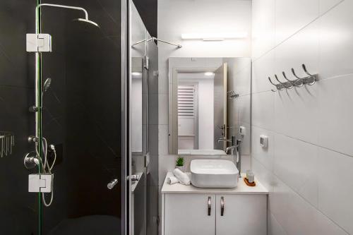 a bathroom with a sink and a shower with a mirror at מגדליה סוויט - סויטה למשפחות עם בריכת זרמים וגקוזי פרטיים in Migdal