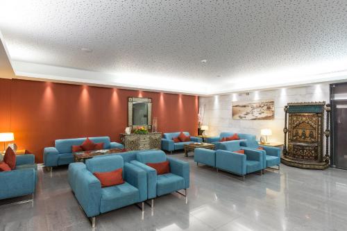 a waiting room with blue couches and orange walls at Muthu Clube Praia da Oura in Albufeira