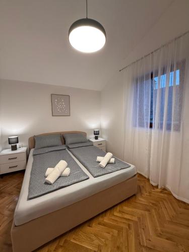 a bedroom with a large bed with two pillows on it at Apartmani Antea in Preko