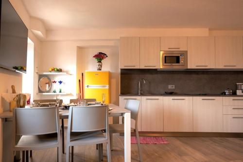 a kitchen with white cabinets and a table and chairs at Casa Guerines in Tremosine Sul Garda