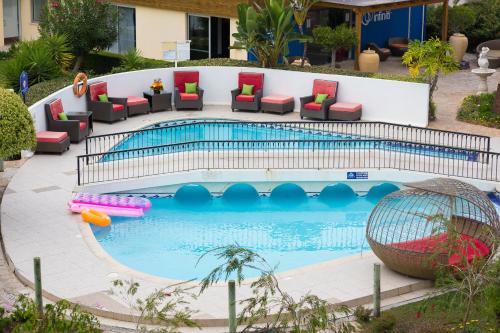 a pool with couches and chairs in a resort at Muthu Clube Praia da Oura in Albufeira