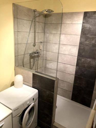 a bathroom with a shower and a washing machine at Appartement moderne climatisé in Nyons