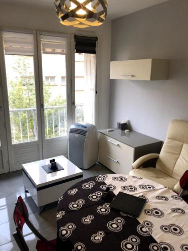 a living room with a bed and a table at Appartement moderne climatisé in Nyons