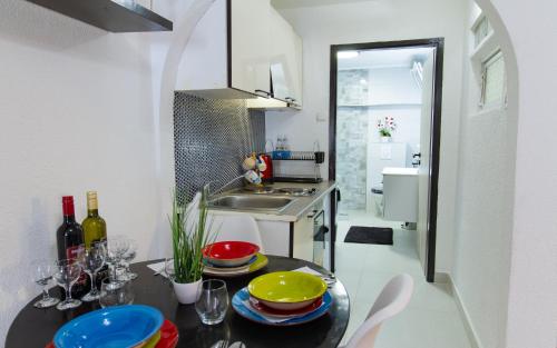 a kitchen with a table with plates and wine glasses at Apartments Coli app Afrodita & Antonia & Veronika in Bakar