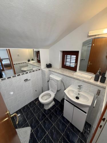 a bathroom with a toilet and a sink at Apartmani Antea in Preko