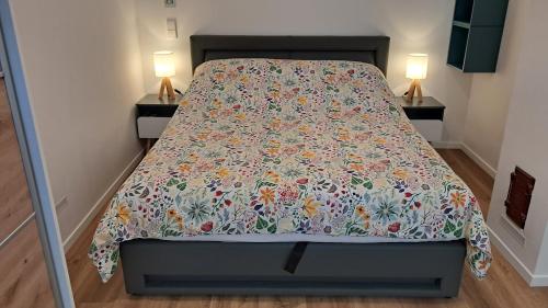 a bed with a flowered bedspread on it in a bedroom at Das Gartenhaus - Lottstetten in Lottstetten