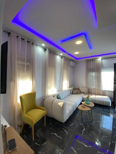 a living room with a white couch and a yellow chair at Green Oasis in Bou Ficha
