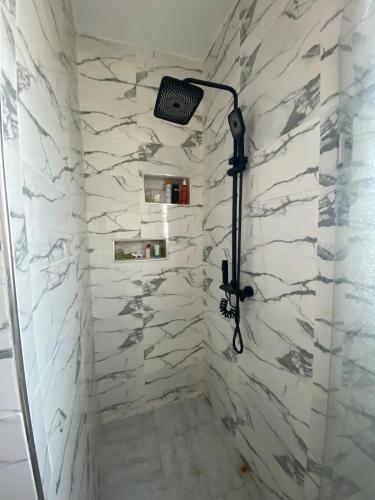 a shower in a bathroom with white marble walls at Green Oasis in Bou Ficha