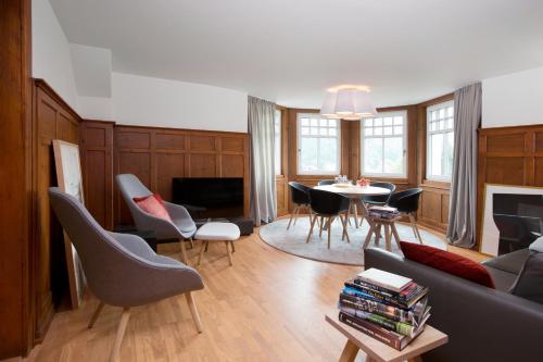 ein Wohnzimmer mit einem Sofa, einem Tisch und Stühlen in der Unterkunft Boutique Apartments Bezau in Bezau