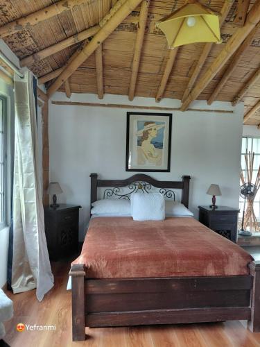 a bedroom with a large bed with two night stands at Iraka Campestre Quindio in El Edén