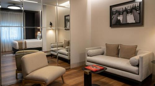 ein Wohnzimmer mit Sofa und Bett in der Unterkunft Hippodrome Hotel in Mexiko-Stadt