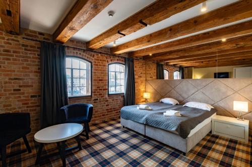 ein Schlafzimmer mit einem Bett und einer Ziegelwand in der Unterkunft Hotel Bulwar Ustka in Ustka