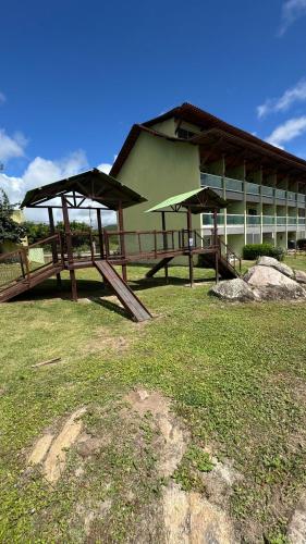 a building with two picnic tables in front of it at Flat em Gravatá - Villa Monte Castelo in Sairé