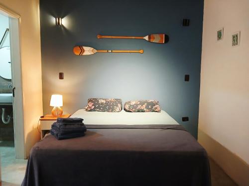 a bedroom with a bed and a wall with two baseball bats at Apartamento em juquehy in São Sebastião