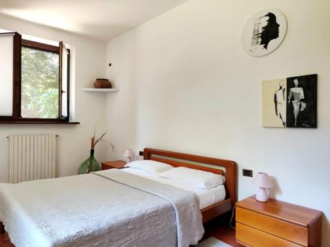 a bedroom with a white bed and a window at Lo Spazio Creativo in Romano Canavese