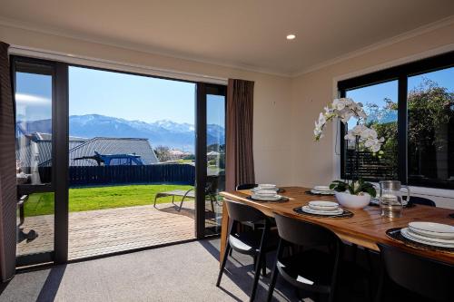 a dining room with a table and a large sliding glass door at Spacious, Family-Friendly, Parkside - KK67479 in Kaikoura