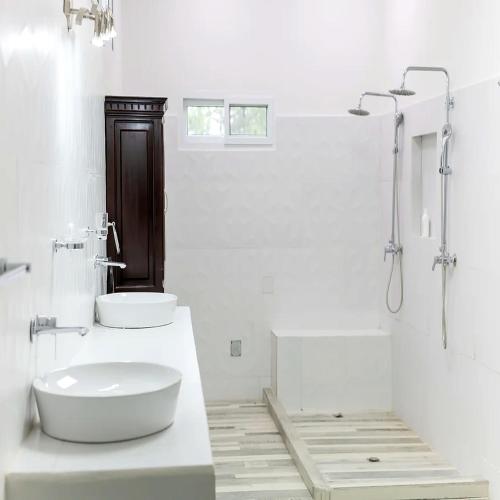 a white bathroom with a sink and a shower at COCOVIEW Hotel in Valle de Ángeles