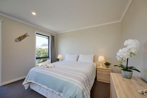 a bedroom with a large bed and a window at Spacious, Family-Friendly, Parkside - KK67479 in Kaikoura