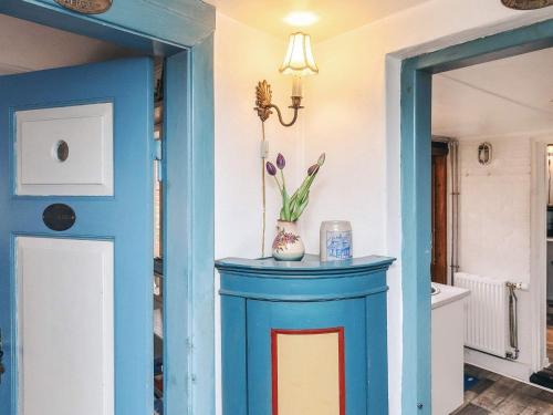 a room with a blue table with a vase of flowers on it at 4 person holiday home in Ærøskøbing-By Traum in Ærøskøbing