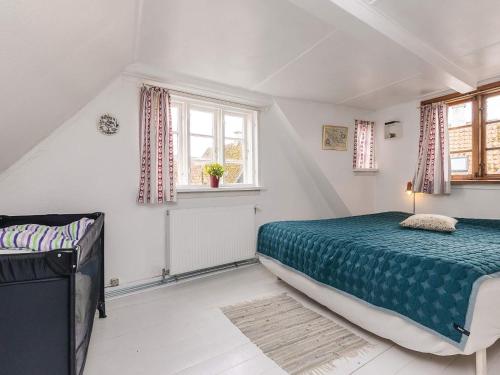 a bedroom with a bed and two windows at 4 person holiday home in Ærøskøbing-By Traum in Ærøskøbing