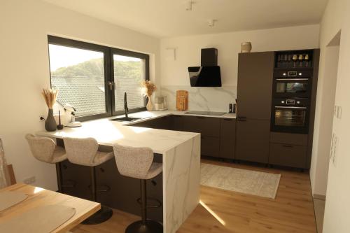 a kitchen with a white island in a room at Design-Villa mit privatem Whirlpool&Naturblick in Wellheim