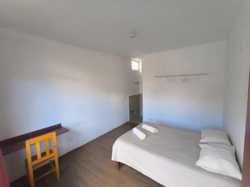 a small bedroom with a bed and a wooden desk at JJ Guest House Kuelap in Nuevo Tingo