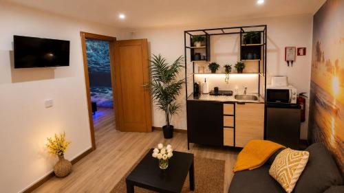 a living room with a couch and a kitchen at 77 Lisbon Design Apartment near Airport, Lisbon, Amadora, Odivelas & Sintra in Caneças