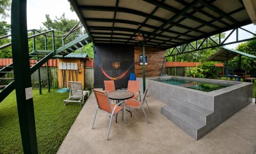a patio with a table and chairs and a pool at Tropical Haus CR - El Manglar in Puerto Jiménez