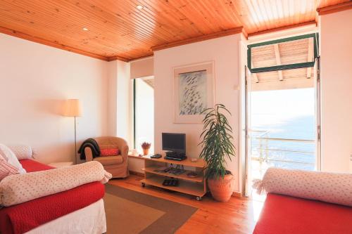 a living room with a couch and a desk with a computer at Casa d'Arriba in Atouguia da Baleia