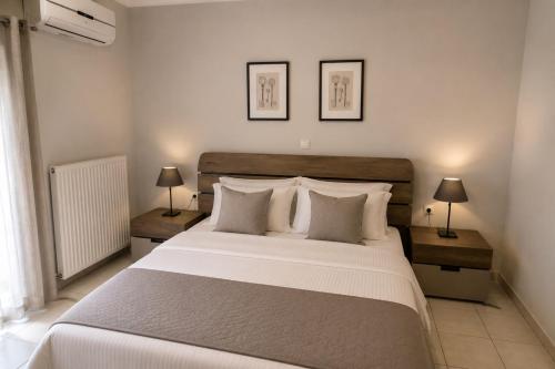 a bedroom with a large white bed with two lamps at Studios Prodromidis Πρεβεζα in Preveza