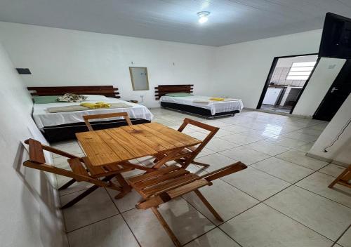 a room with two beds and a table and chairs at Margarida AP 3 in Presidente Figueiredo