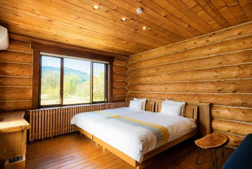 a bedroom with a bed in a log cabin at Reposer Hakuba Hotel and Offsite Villa in Hakuba