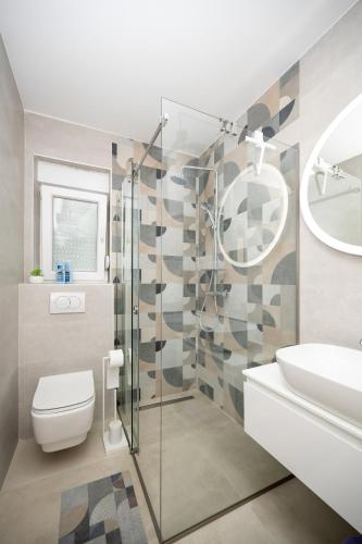 a bathroom with a shower and a toilet and a sink at Apartments by the sea Stara Novalja, Pag - 6301 in Stara Novalja