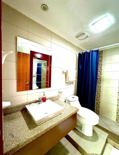 a bathroom with a toilet and a sink and a mirror at lighthouse view piso 8 in Guayaquil