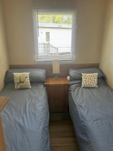 two beds in a small room with a window at Cleethorpes beach haven site in Cleethorpes