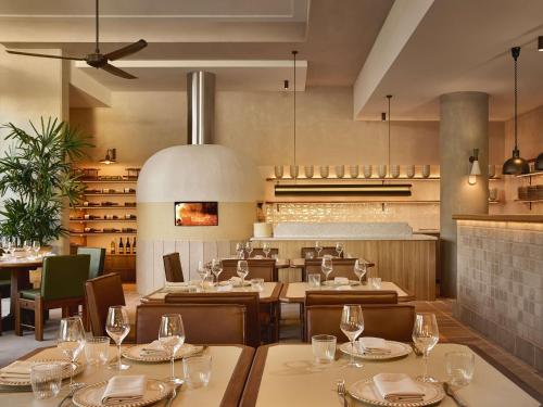 a dining room with tables and chairs and a restaurant at Mondrian Gold Coast in Gold Coast