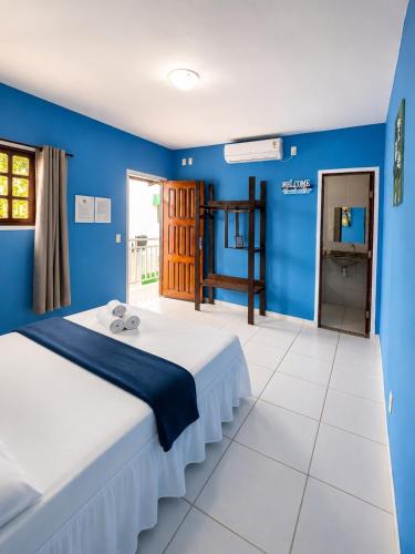 a bedroom with blue walls and a large bed at Pousada Jardim Mágico in Ponta Negra