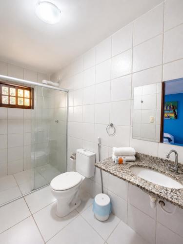a bathroom with a toilet and a sink and a shower at Pousada Jardim Mágico in Ponta Negra