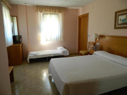 a hotel room with two beds and a window at Hermida Rural in Eirejalba