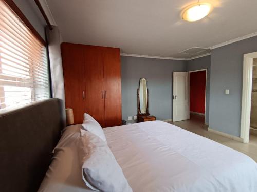 a bedroom with a large white bed and a window at Toekies and Abel in Cape Town
