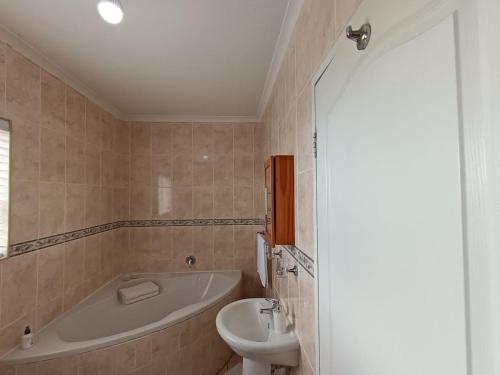 a bathroom with a tub and a toilet and a sink at Toekies and Abel in Cape Town