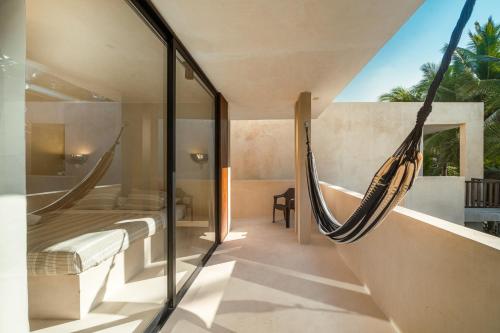 a room with a hammock in a house at Cocuna Boutique Suites La Manzanilla Jalisco in La Manzanilla