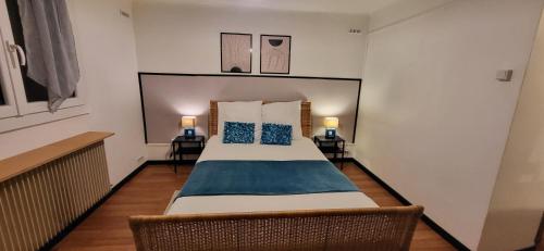 a bedroom with a large bed with blue pillows at Appartement Chaleureux avec Jardin proximité Métro in Marseille