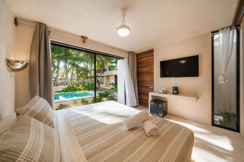a bedroom with a bed and a large window at Cocuna Boutique Suites La Manzanilla Jalisco in La Manzanilla