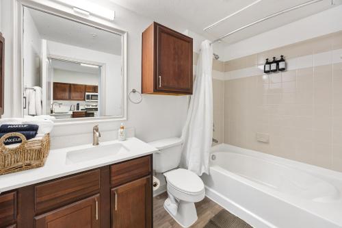 a bathroom with a sink and a toilet and a tub at Relaxing Getaway with Pool view & Gym in Frisco