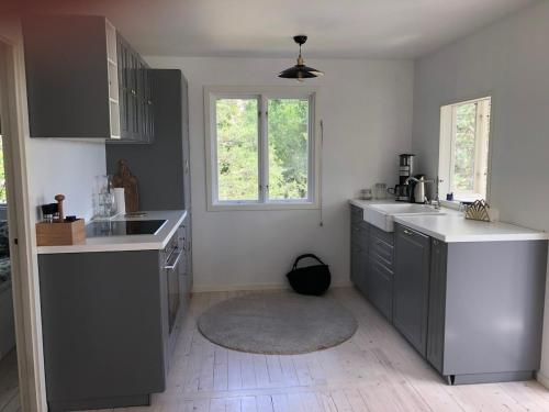 a kitchen with gray cabinets and a sink and a window at Das Elchhaus in Saltsjöbaden
