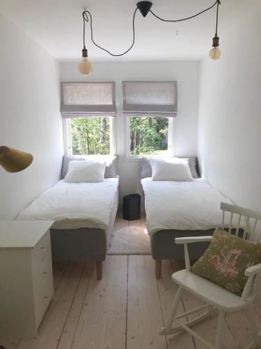 a bedroom with two beds and a desk and a chair at Das Elchhaus in Saltsjöbaden